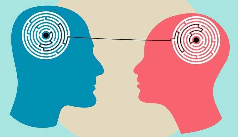 Silhouette des Kopfes eines Mannes und einer Frau mit einem Labyrinth im Inneren, das psychologische Prozesse des Verstehens symbolisiert.