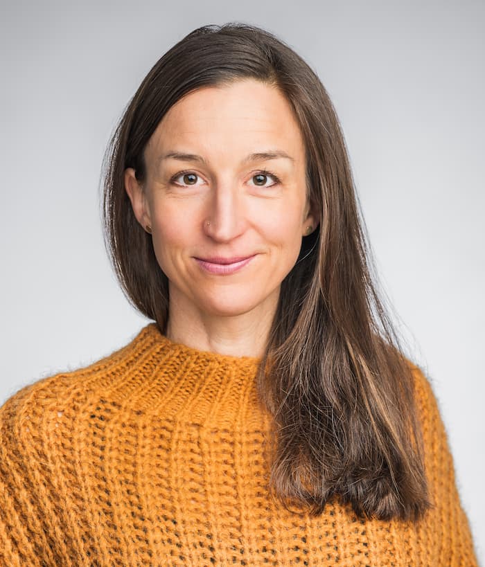 Portrait von Psychotherapeutin Hannah Adenauer in einem gelben Strickpullover.